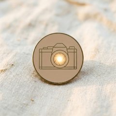 Proof of Patronage enamel-pin badge - a line-art vintage SLR camera with a glowing lens.
